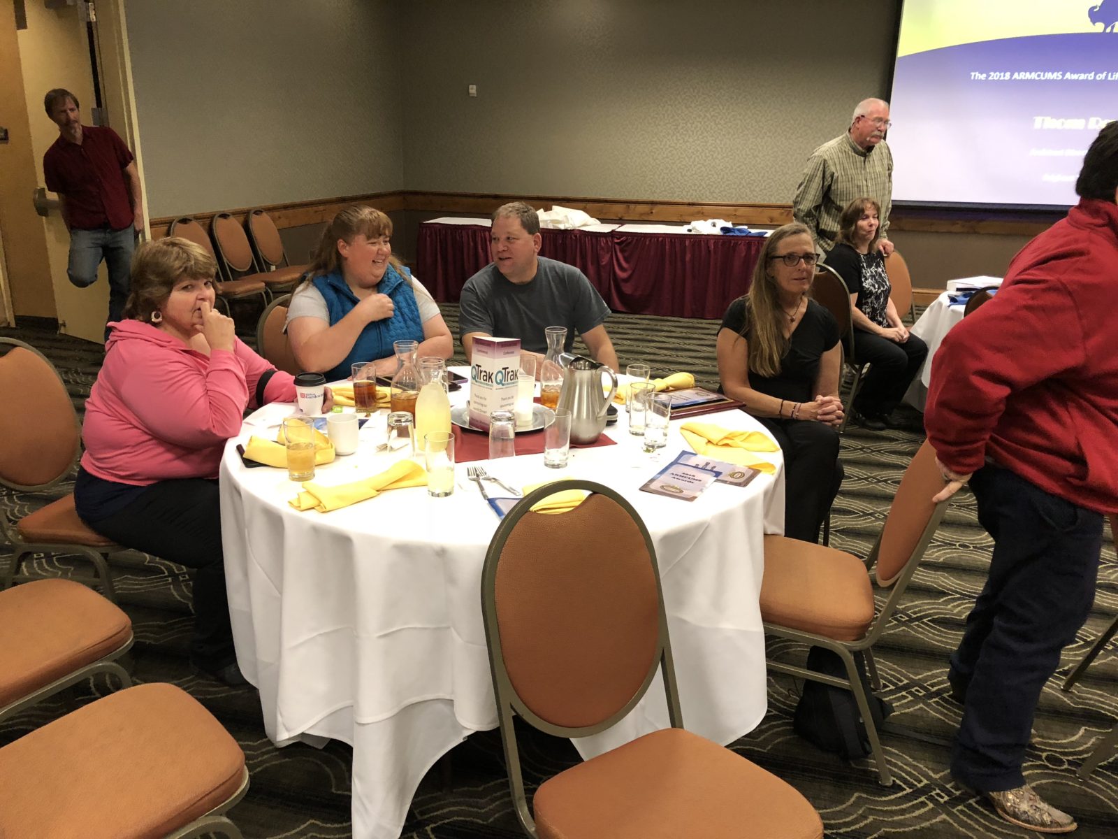 People enjoying a meal at a round table in a conference room.