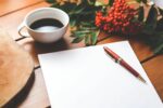 Blank paper with pen, coffee, and berries.