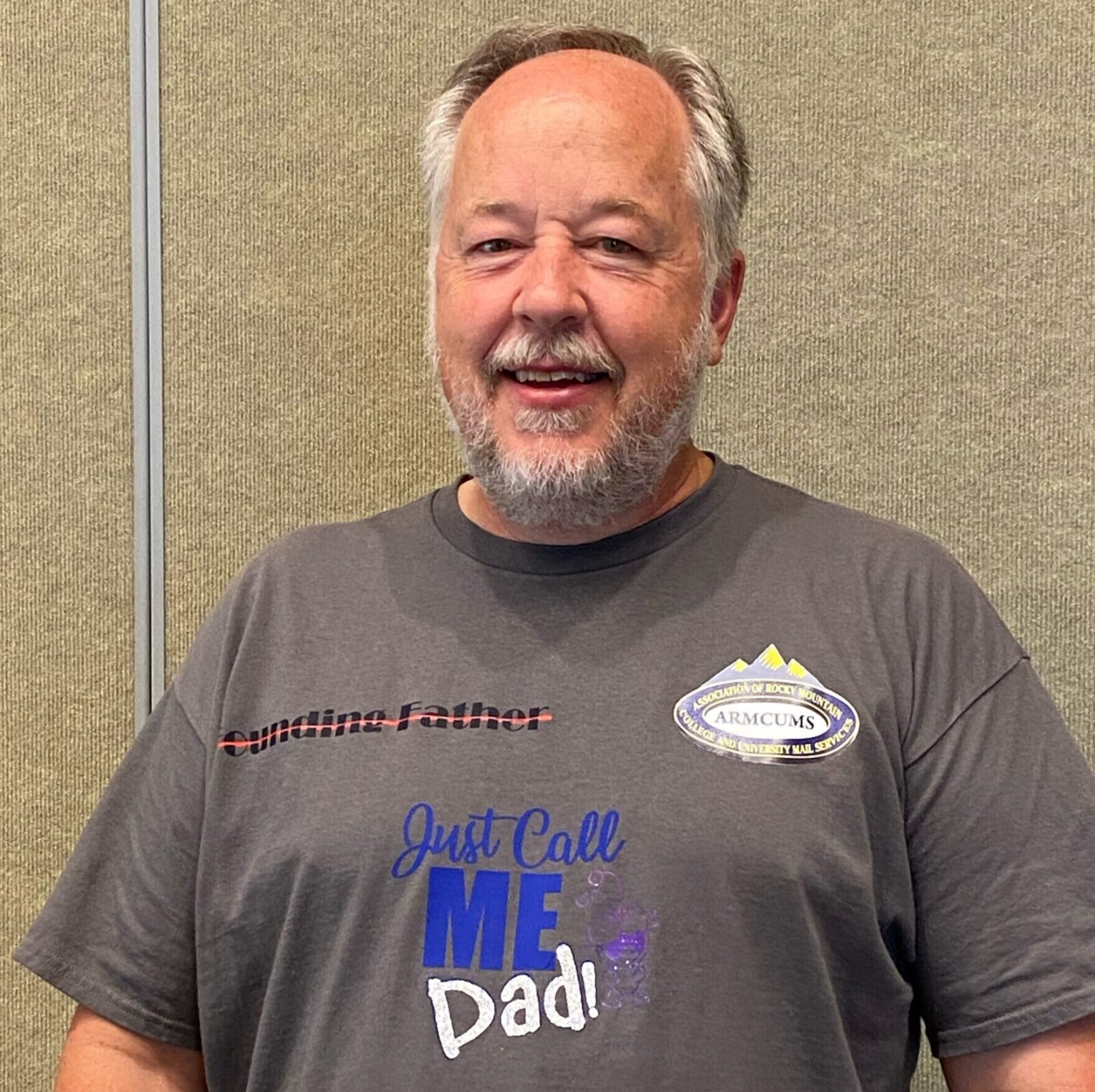 Smiling man wearing a gray shirt with a 'Call me Dad!' graphic.
